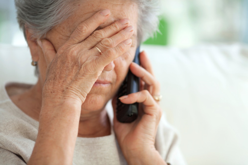 Elderly woman frustrated with cell phone fraud