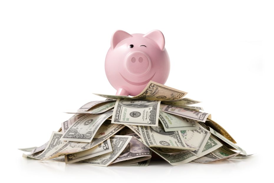 a smiling pink piggy bank on top of a pile of money